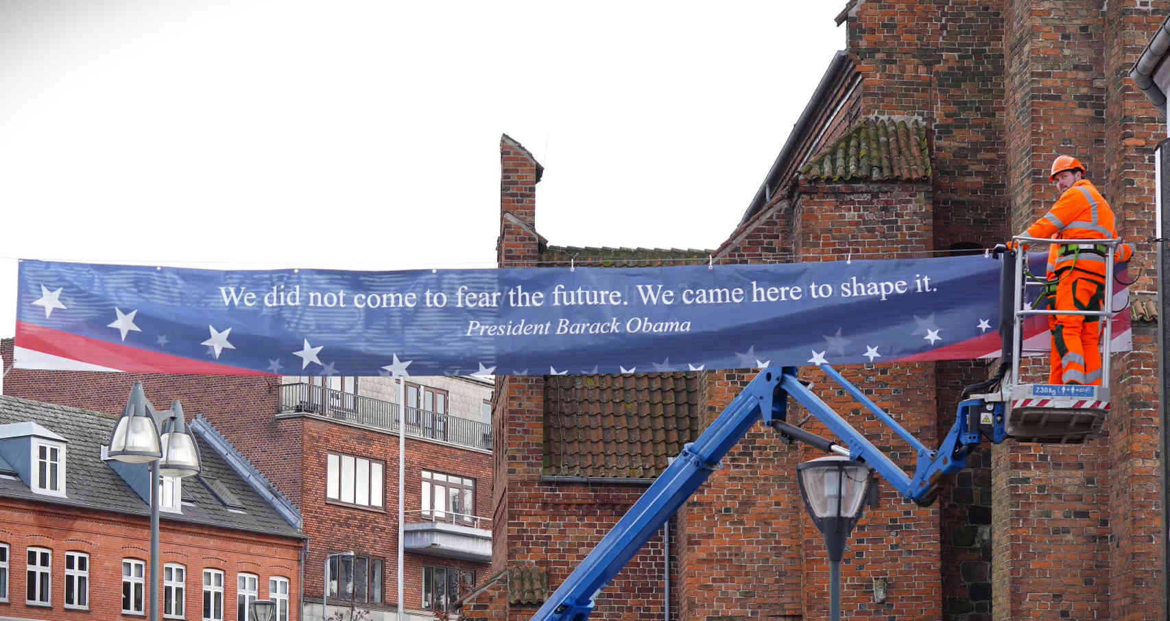 Billede af banner som bliver hængt op i Næstved by med citat fra en amerikansk præsident