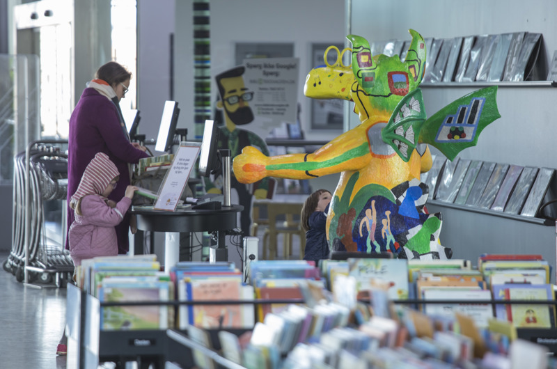 Billede af to personer der ser på bøger fra Næstved Hovedbibliotek
