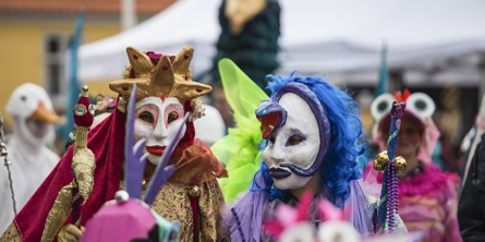 To personer med karnevalsmasker og farvestrålende tøj