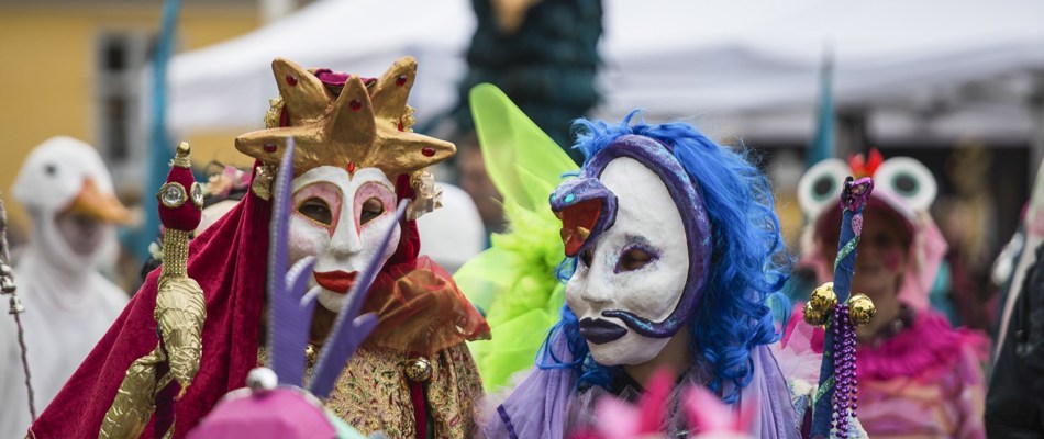 To personer med karnevalsmasker og farvestrålende tøj