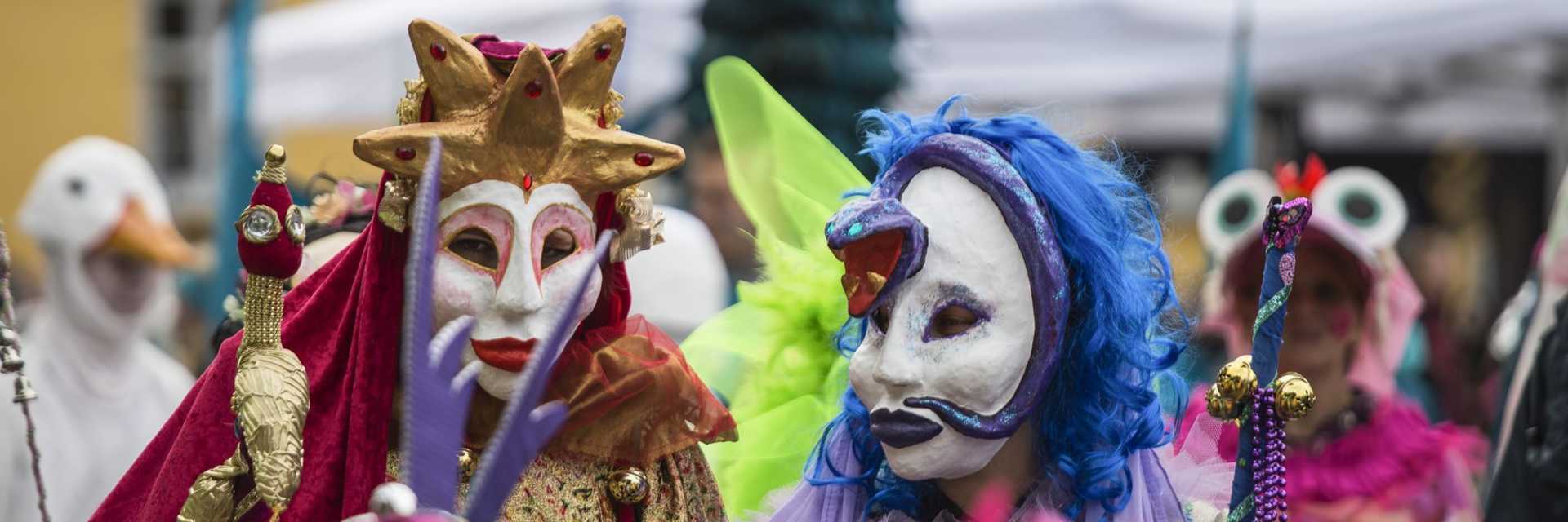 To personer med karnevalsmasker og farvestrålende tøj