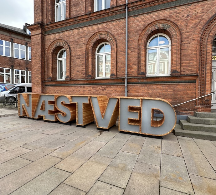 Gammel murstensbygning med bogstaver foran, hvor der står NÆSTVED.