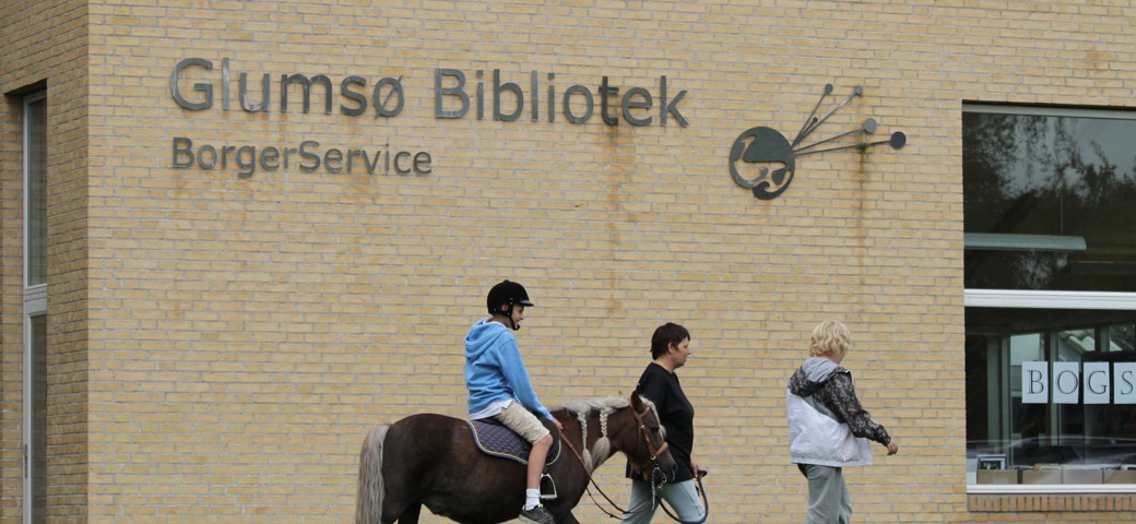 Barn trækkes på pony foran Glumsø Bibliotek Og Borgerservice