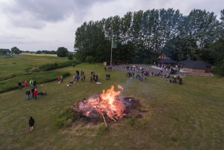 Mennesker står samlet omkring Sankt Hans Bål Ved Friluftszonen i Herlufmagle