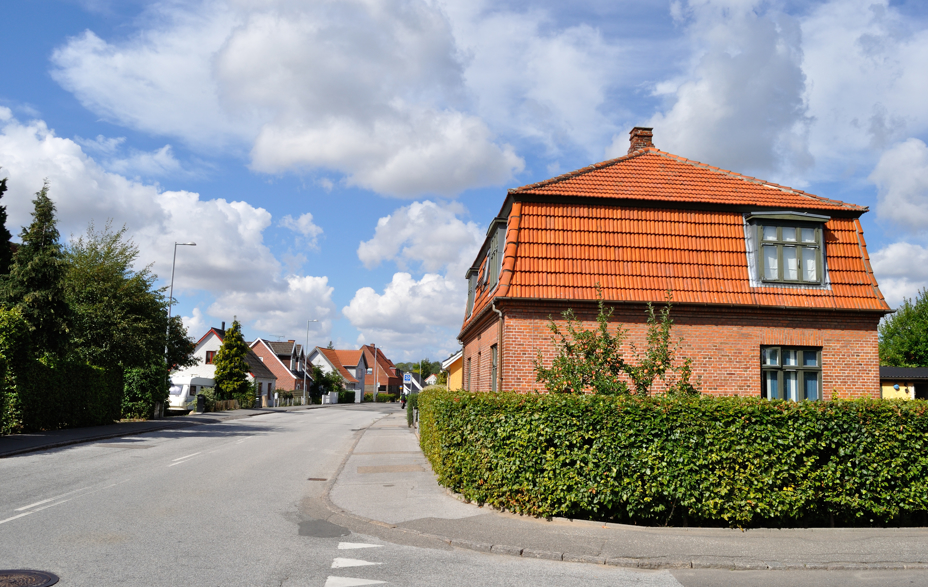 Billed af den privatvej som støder op til en offentligvej med huse ved vejen