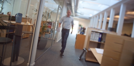 En mand går på gangen i en kontormiljø