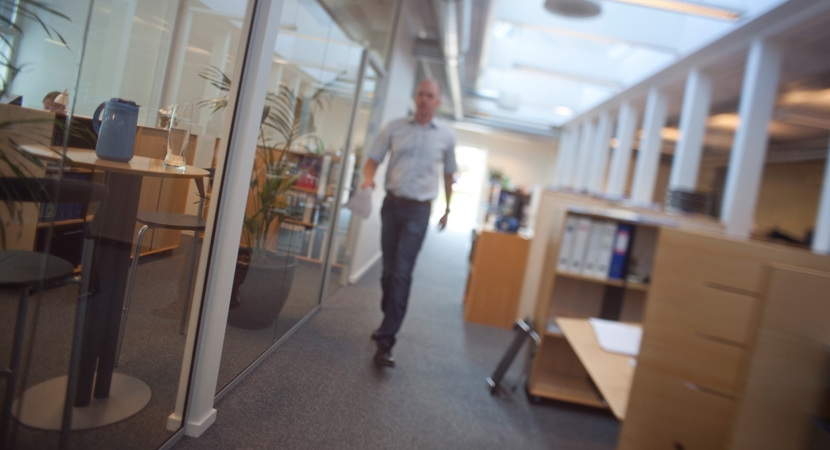 En mand går på gangen i en kontormiljø