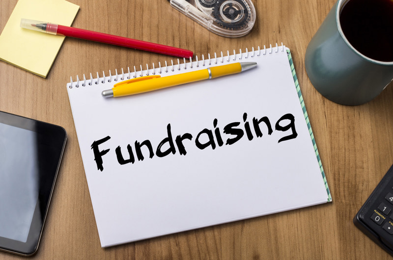 Ordet Fundraising skrevet på en blok som ligger på et bord
