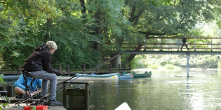 Dreng sidder i campingstol ved Susåen og fisker