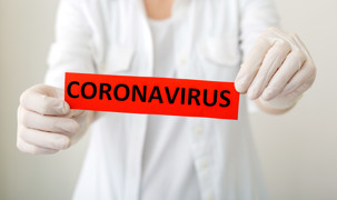 Sundhedsperson viser Coronaskilt Sundhedsperson viser Coronaskilt