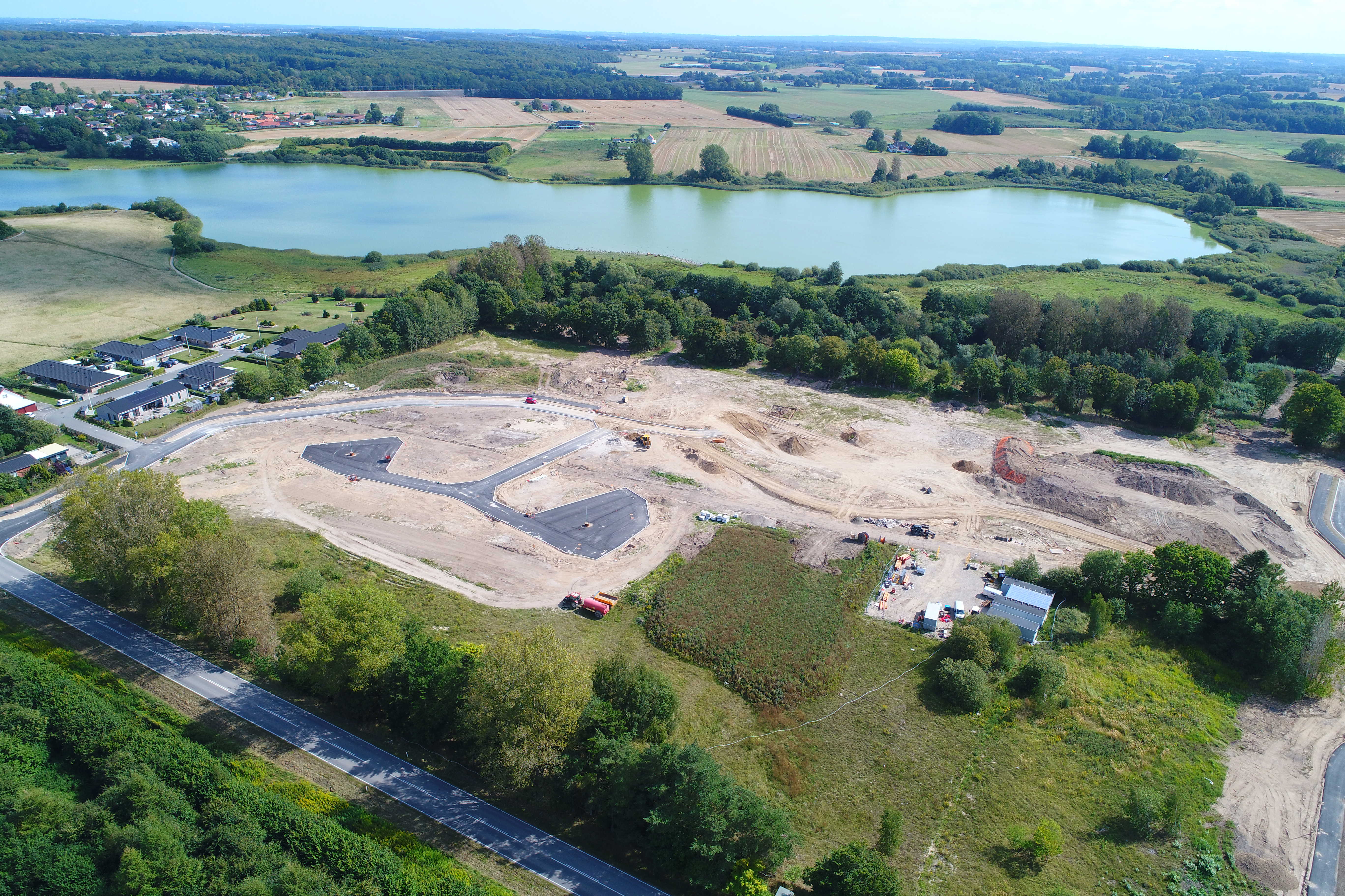 Dronefoto ud over grundene mod søen