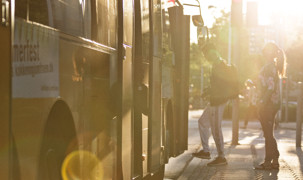 Bus ses i kørerretning og man ser vejen i sollysetsskær Bus ses i kørerretning og man ser vejen i sollysetsskær