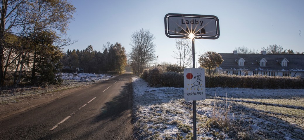Byskilt i solen på vej ind i Ladby