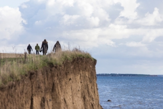 Mennesker på vej væk fra klint ved vandet