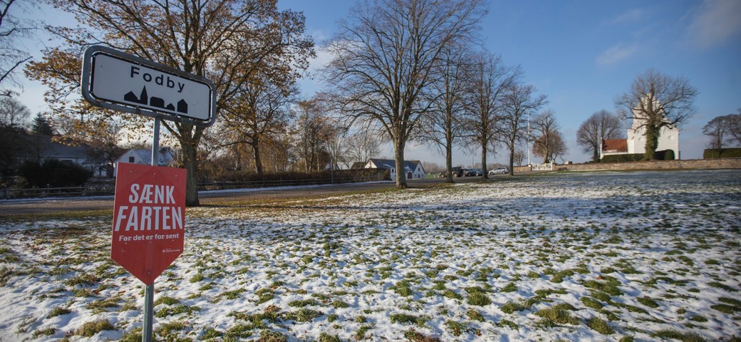 Fodby byskilt på snedækket landskab foran Fodby kirke
