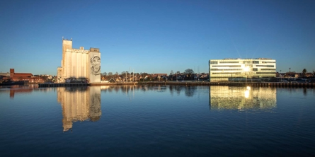 Siloer og Max-bankbygningen spejlet i havnebassinet i Næstved havn.