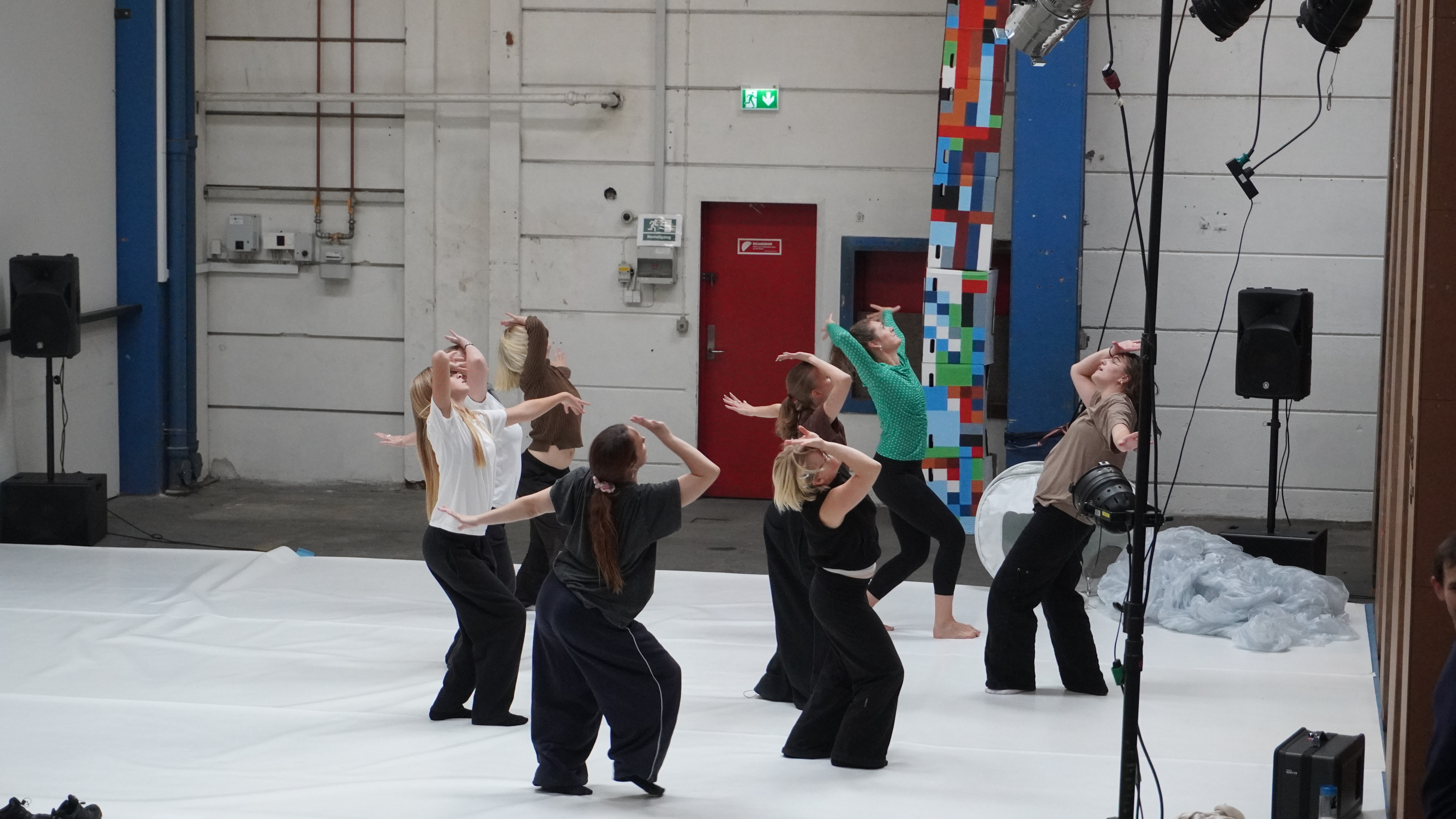 Dansere på midten af et gulv i en sal. 