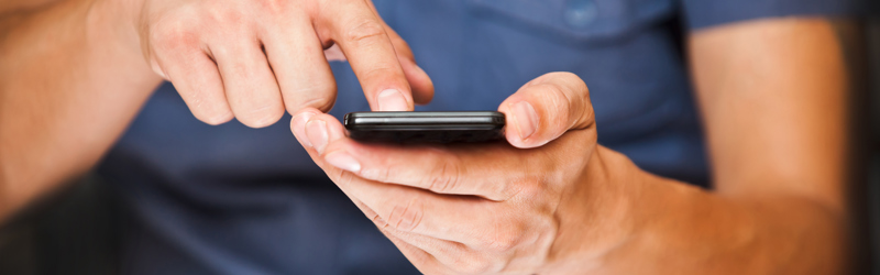 Mand der holder en mobiltelefon