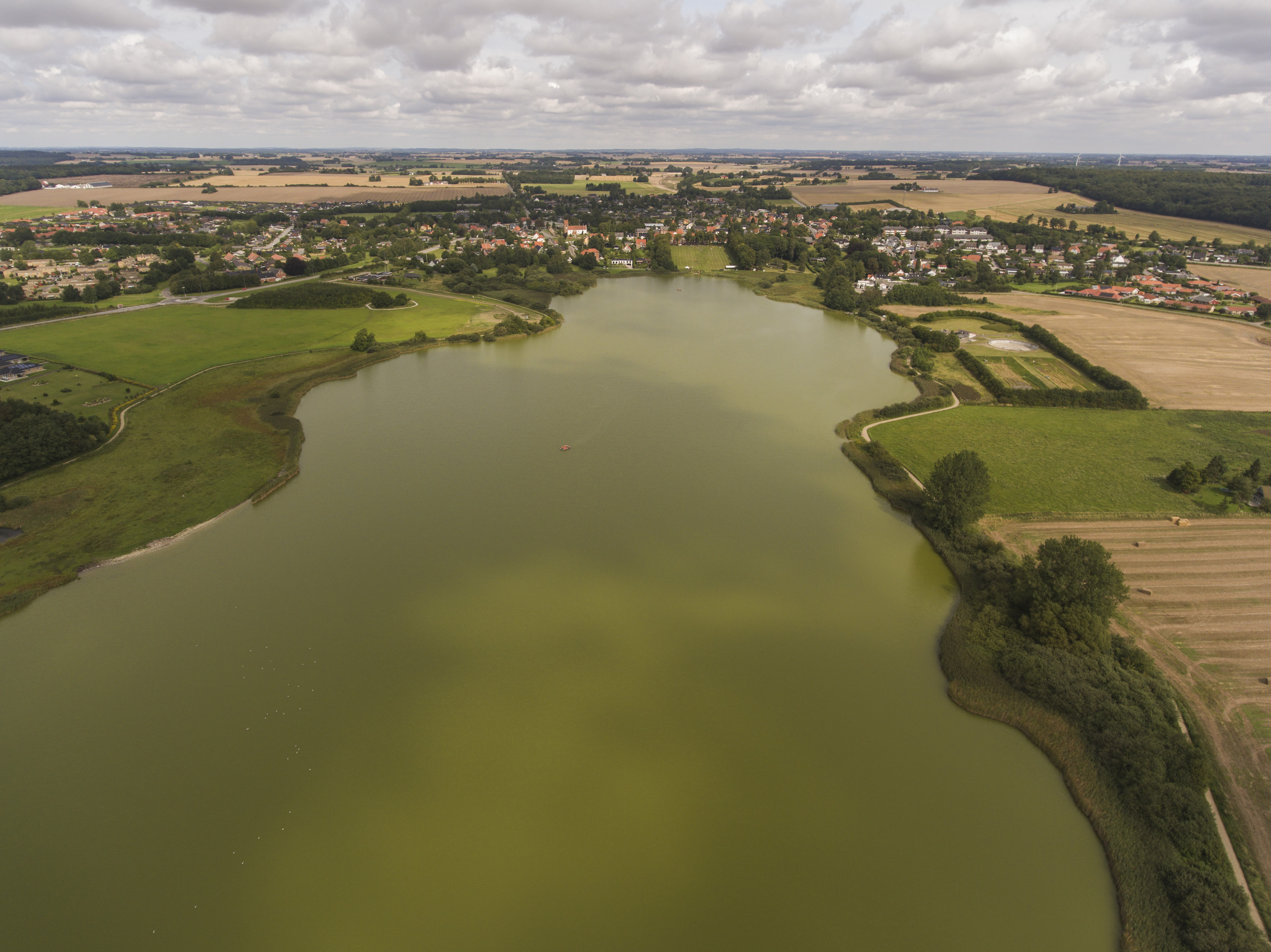 Grøn sø med udsigt indover en by