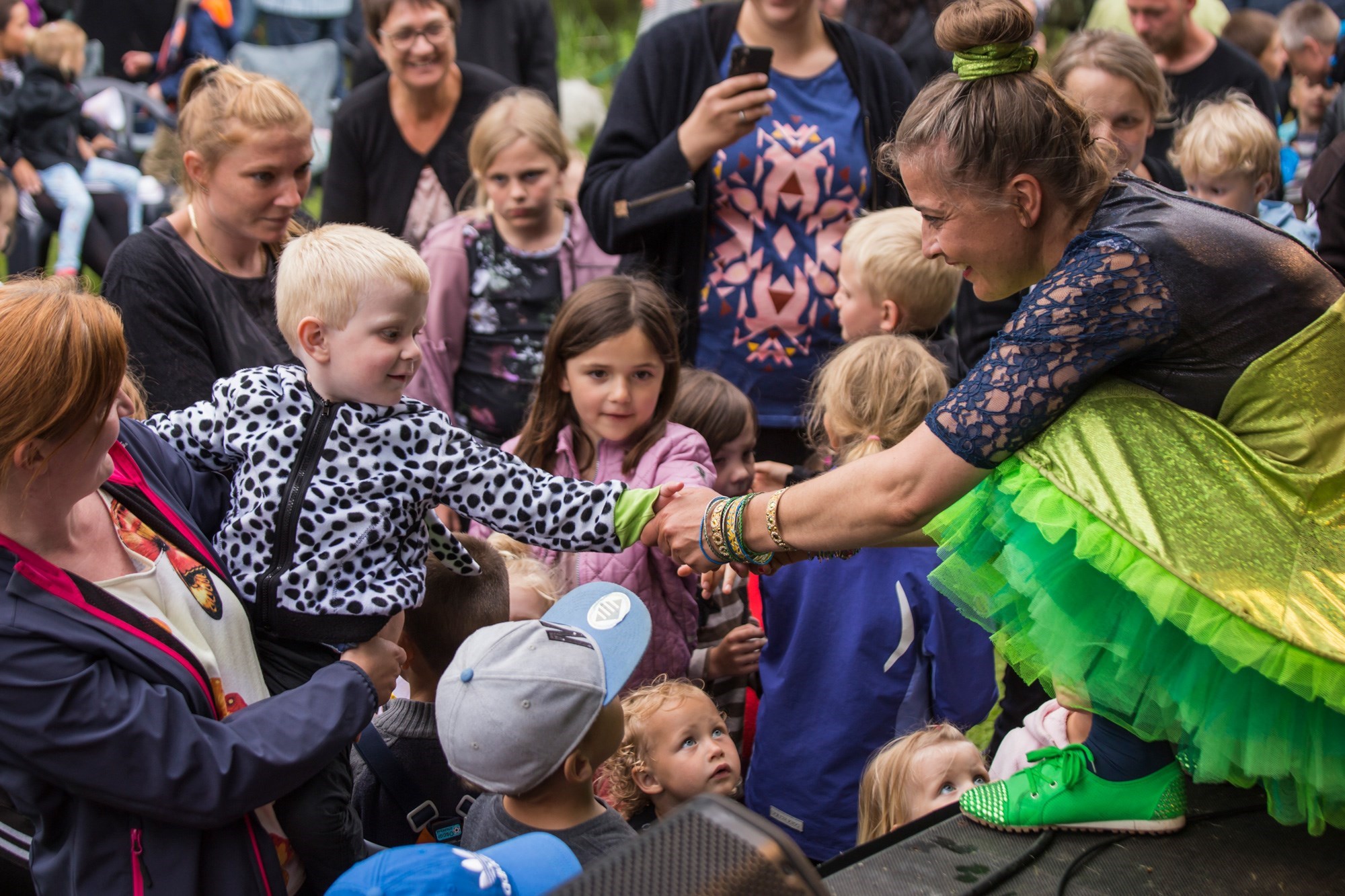 Kvinde på scene holder et barn bandt publikum i hånden 