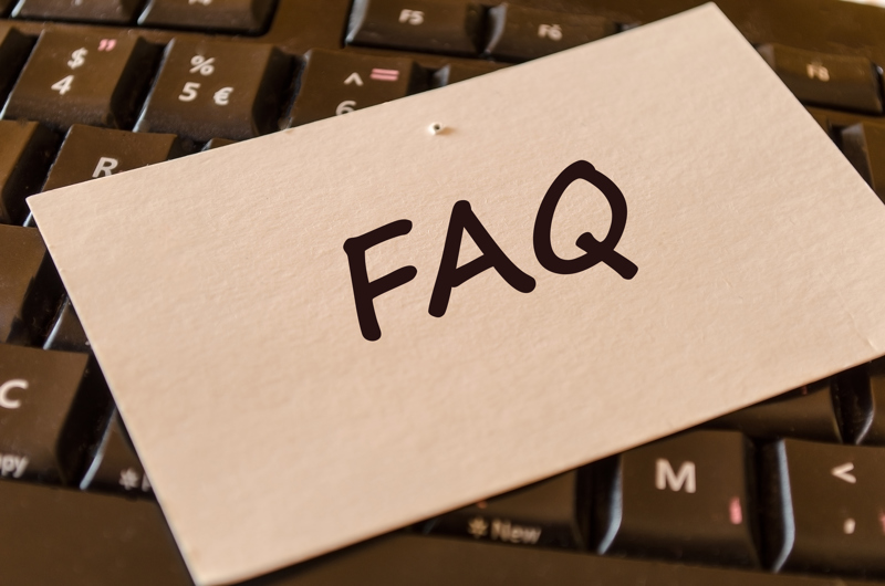 Et skilt med teksten FAQ, som er fastgjort til et tastatur