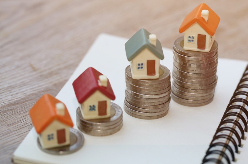 Fire små huse, der står ovenpå mønter