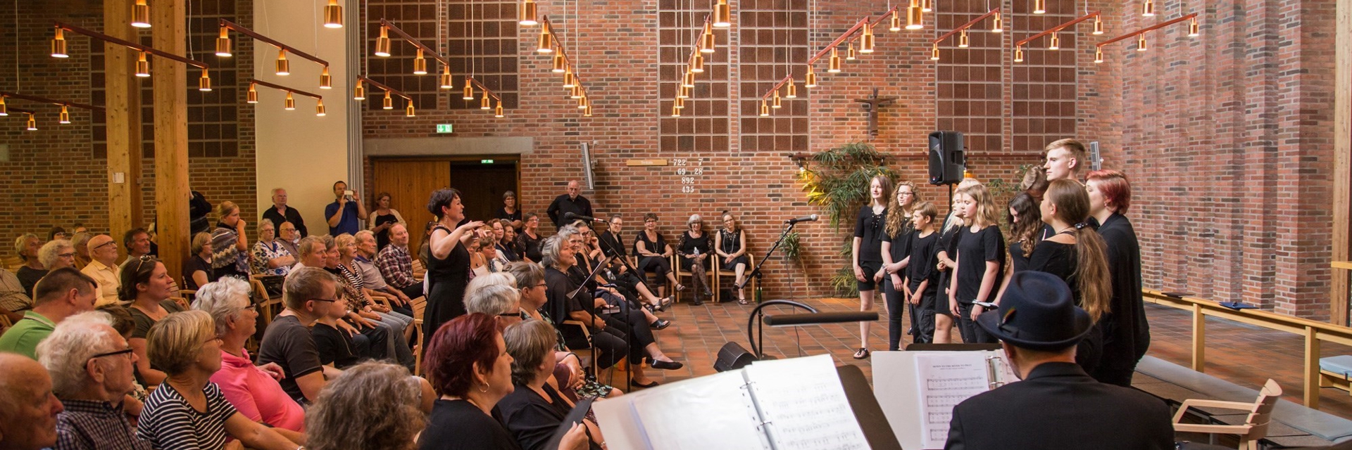 Et pigekor synger foran publikum i en kirke