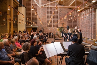 Et pigekor synger foran publikum i en kirke