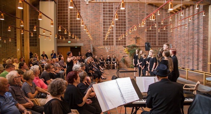 Et pigekor synger foran publikum i en kirke