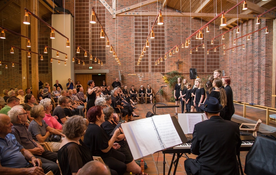 Et pigekor synger foran publikum i en kirke