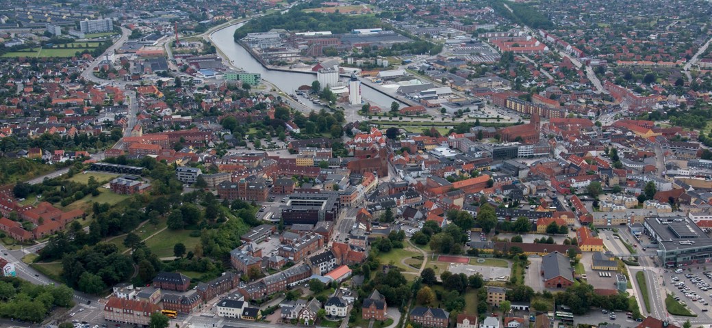 Dronefoto af Næstved Bymidte, havn og Banegården