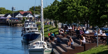 Mennesker sidder ved trappe foran Fiskebutik i Karrebæksminde