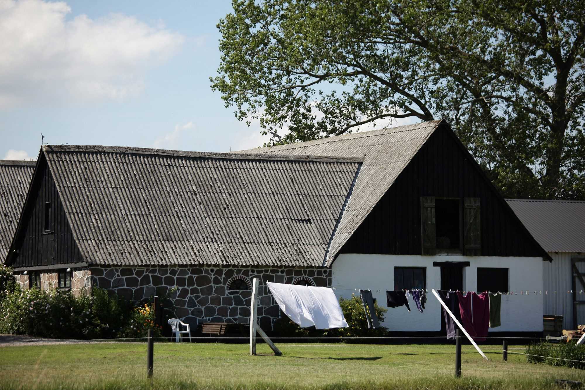 Et bondehus med vasketøj der hænger til tørre udenfor