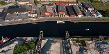 Droneudsigt over kanalen i Næstved lige inden havnebassin med kraner